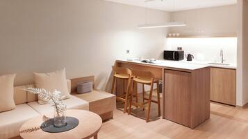 A modern kitchen with a central island, bar stools, and a dining area with a round table.