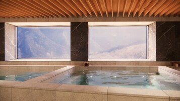 Un área de spa con un ventanal grande, techo de madera y piso de baldosas.