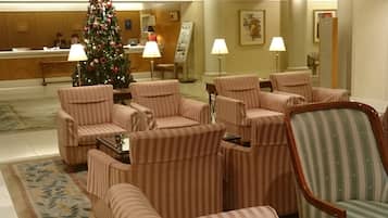 Un vestíbulo con sofás a rayas, un árbol de Navidad y una mesa de recepción.
