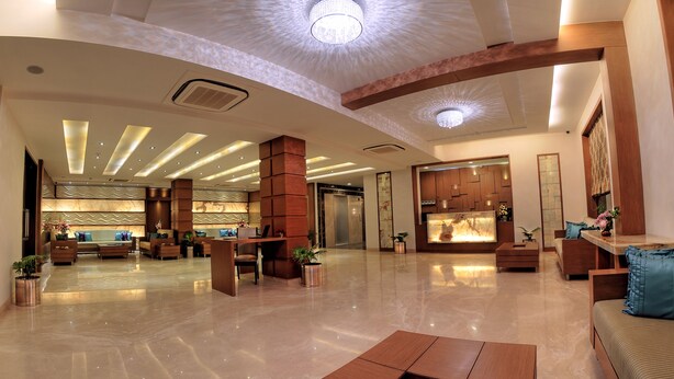 A spacious lobby with a high ceiling, modern lighting, and a reception desk. - The Retreat (Agra)
