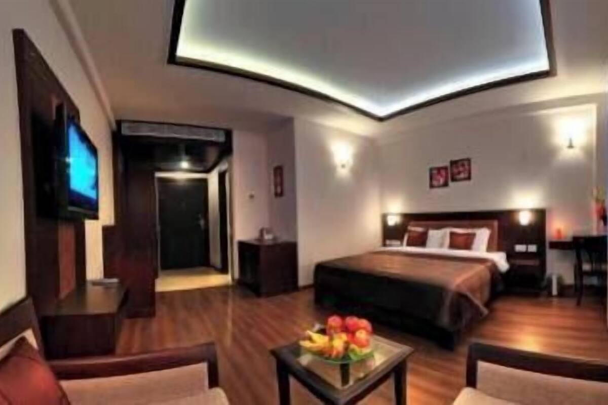Ein Hotelzimmer mit Bett, Fernseher, Schreibtisch und Stuhl.