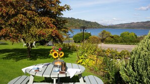 A picnic table with a view of a lake and hills. - Knipoch House Hotel (Oban)