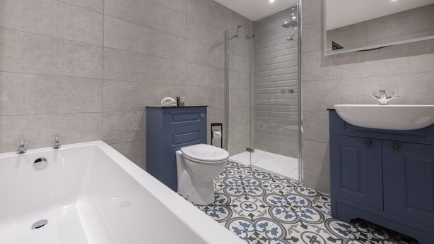 A modern bathroom with a bathtub, toilet, and shower area. - Knipoch House Hotel (Oban)