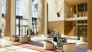 A spacious lobby with a large chandelier, seating areas, and a staircase. - Fairmont Baku - Flame Towers (Baku)