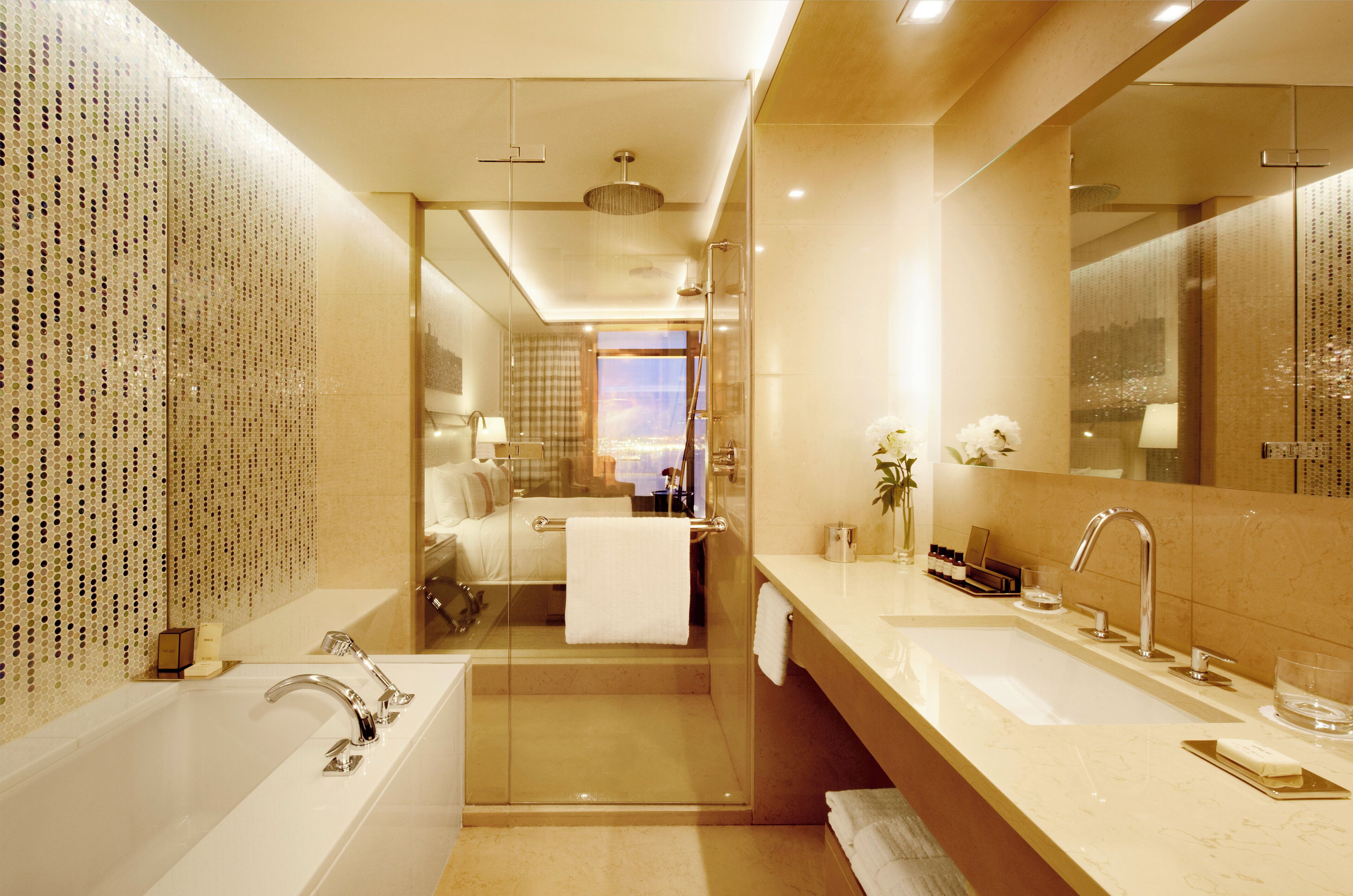 A modern bathroom with a glass-enclosed shower, a large mirror, and a vanity with a sink.