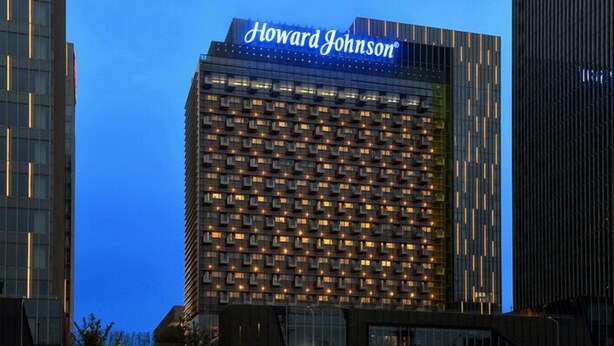 Un immeuble de grande hauteur sur lequel on peut voir en évidence, au sommet, l’enseigne « Howard Johnson ».