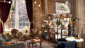 A cozy living room with a sofa, armchairs, a coffee table, and a bookshelf. - Canvas Hotel Dallas (Dallas)