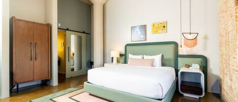 Une chambre à coucher avec un lit, des tables de chevet, une armoire et un miroir.