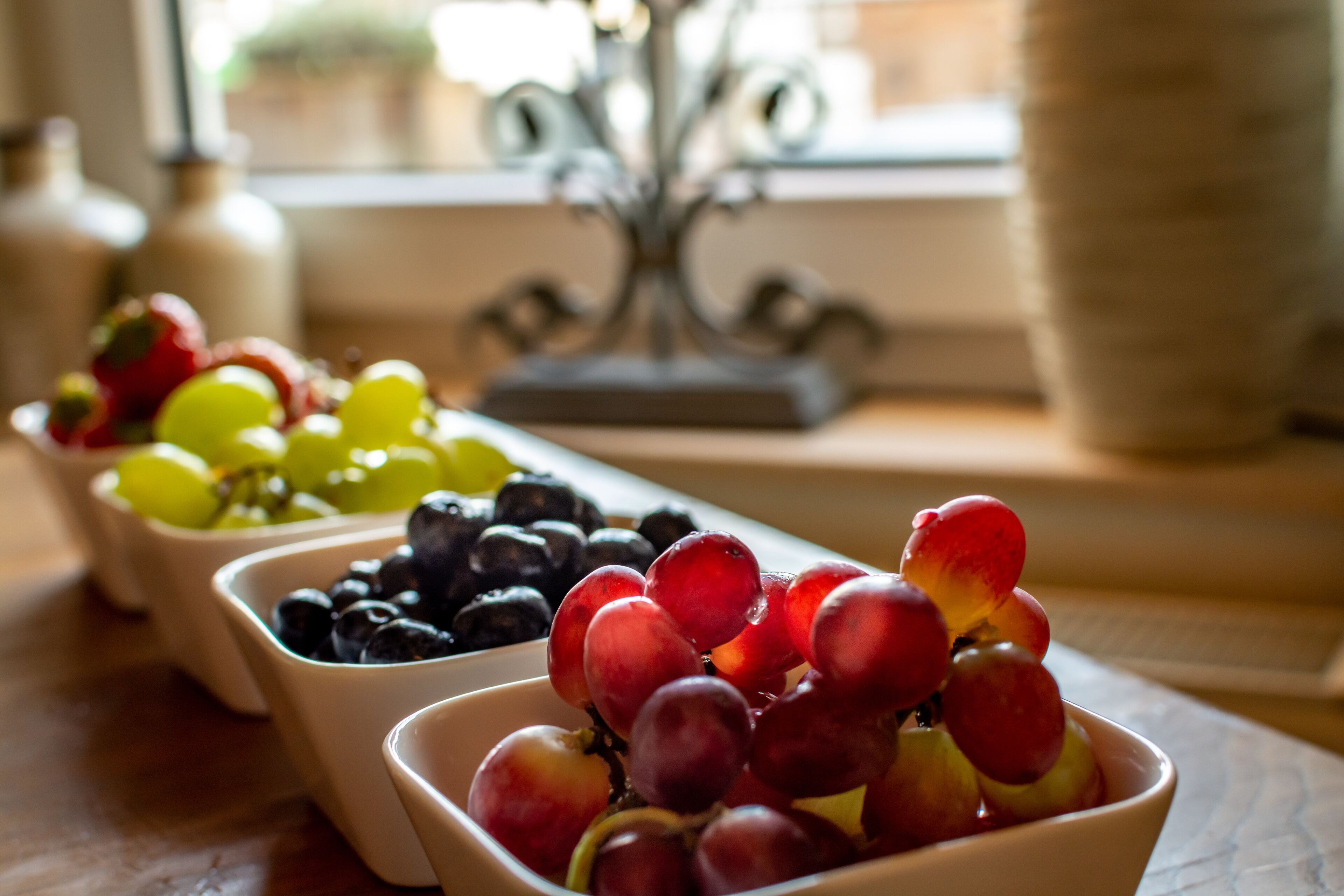Drie schalen met fruit op een tafel.