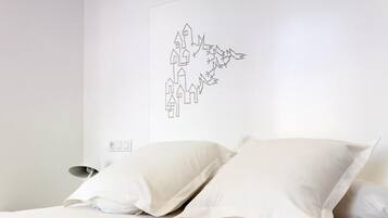 Ein Schlafzimmer mit einem Bett, zwei Kissen, einem Nachttisch und einem Stadtbild an der Wand.