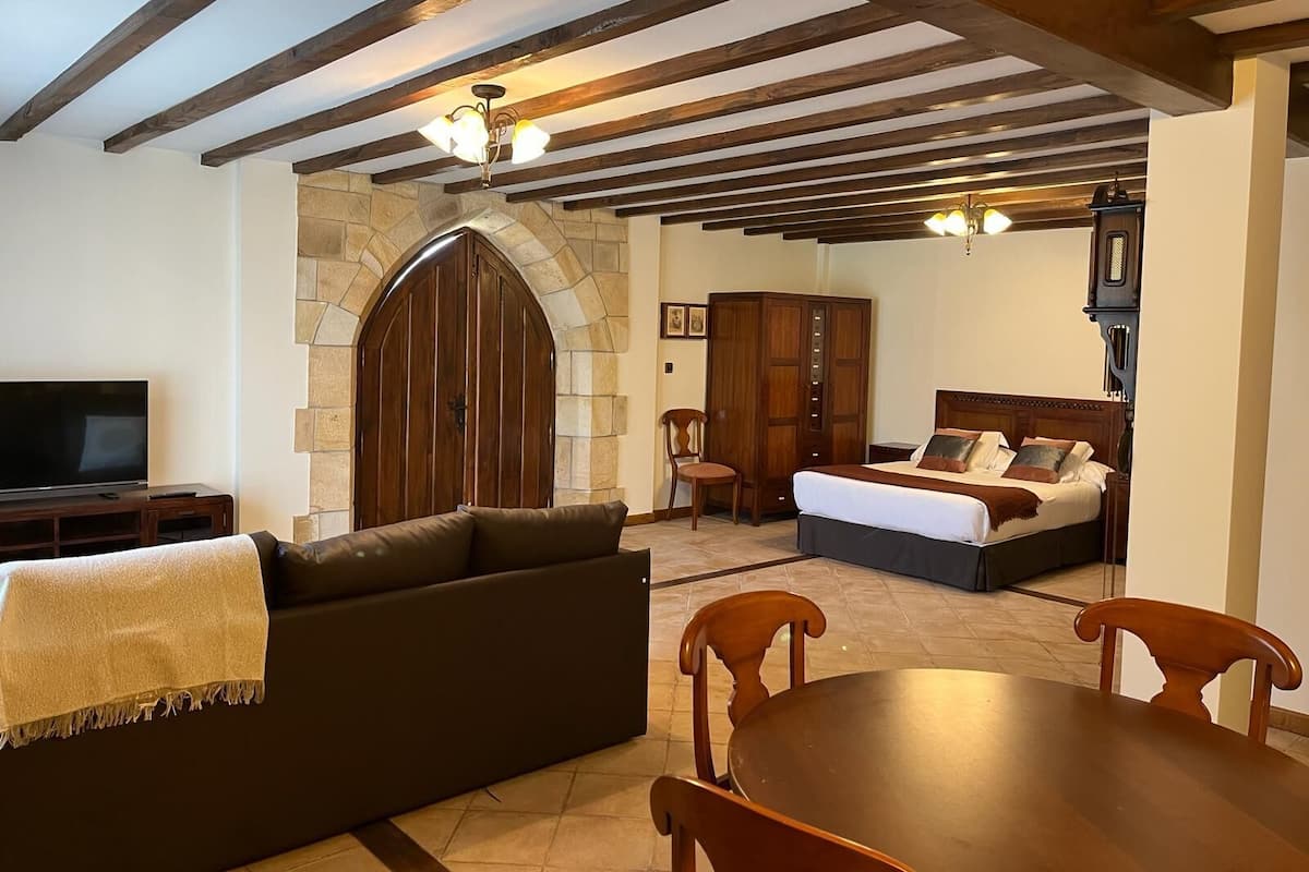 Uma sala de estar aconchegante com sofá, televisão, lareira e mesa de jantar com cadeiras.