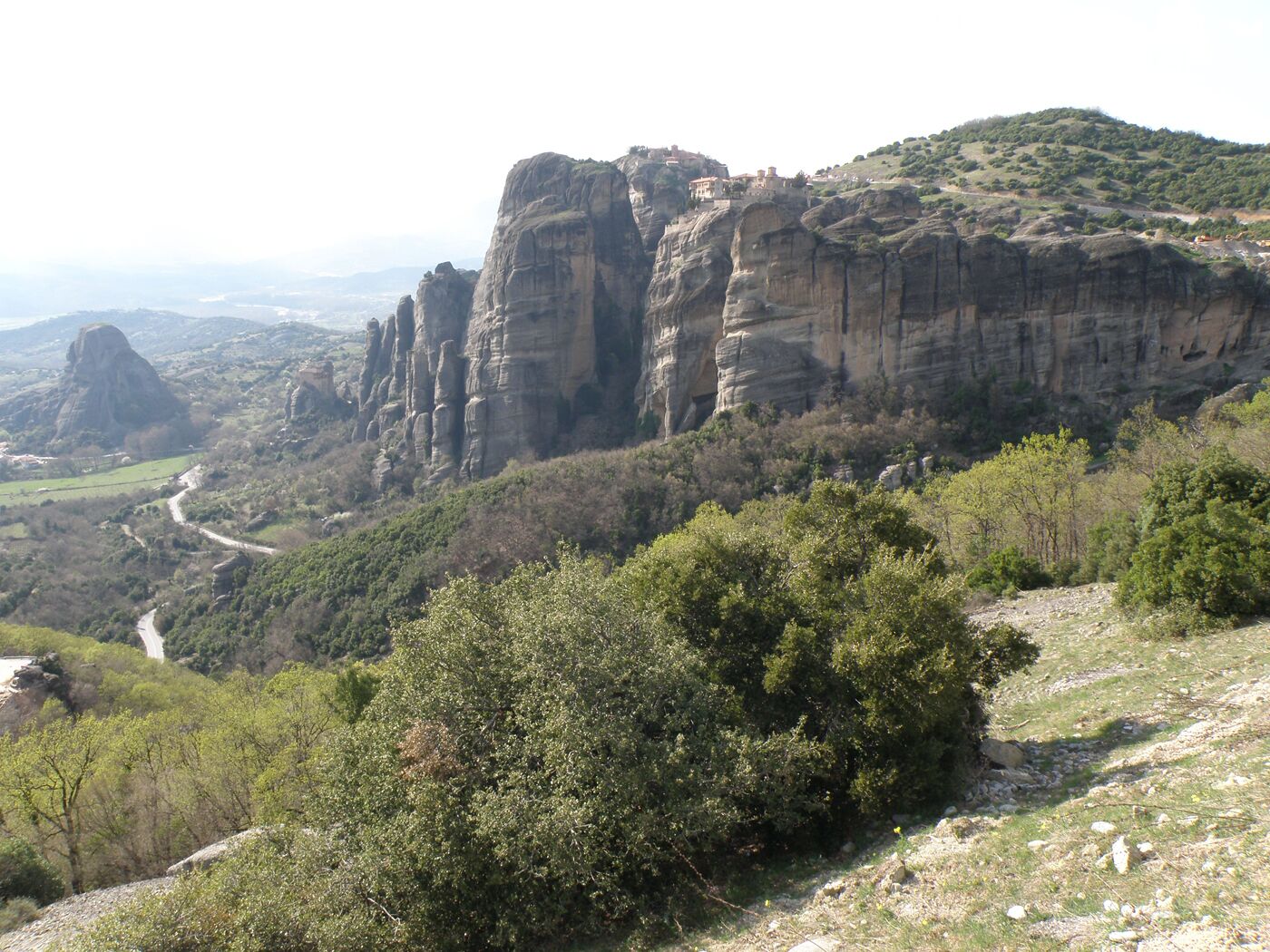 A mountainous landscape with rocky cliffs and dense greenery.