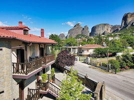 Una zona residencial con edificios de piedra, tejados de tejas rojas y una calle que conduce a una puerta.