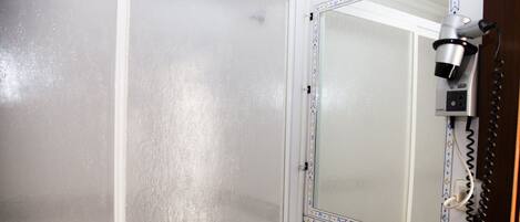 Un baño con lavamanos blanco, un espejo con marco decorativo y un secador de pelo en la pared.