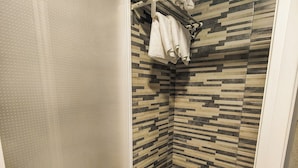 A shower with a patterned tile wall and a white towel rack. - Hostal París (La Línea de la Concepción)
