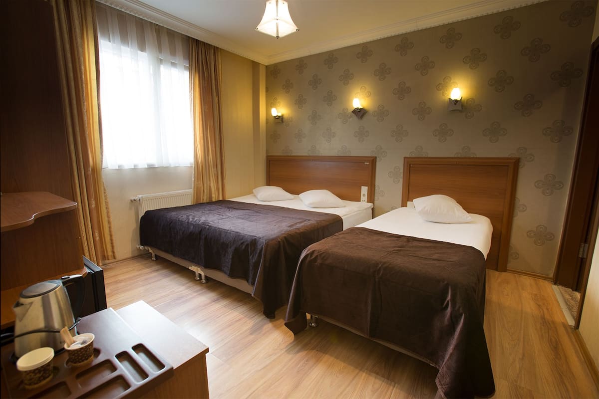 Triple Room | Een minibar, een kluis op de kamer, een bureau, verduisterende gordijnen
