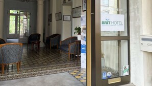 Een hotel lobby met een receptiebalie, een zithoek en een kroonluchter.