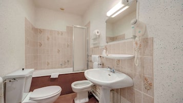Ein Badezimmer mit Toilette, Bidet, Waschbecken und Spiegel.