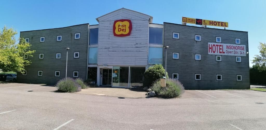 Un hotel con un cartel que indica "P'tit Dej" y "HOTEL INSONORISE", señalando servicio las 24 horas.