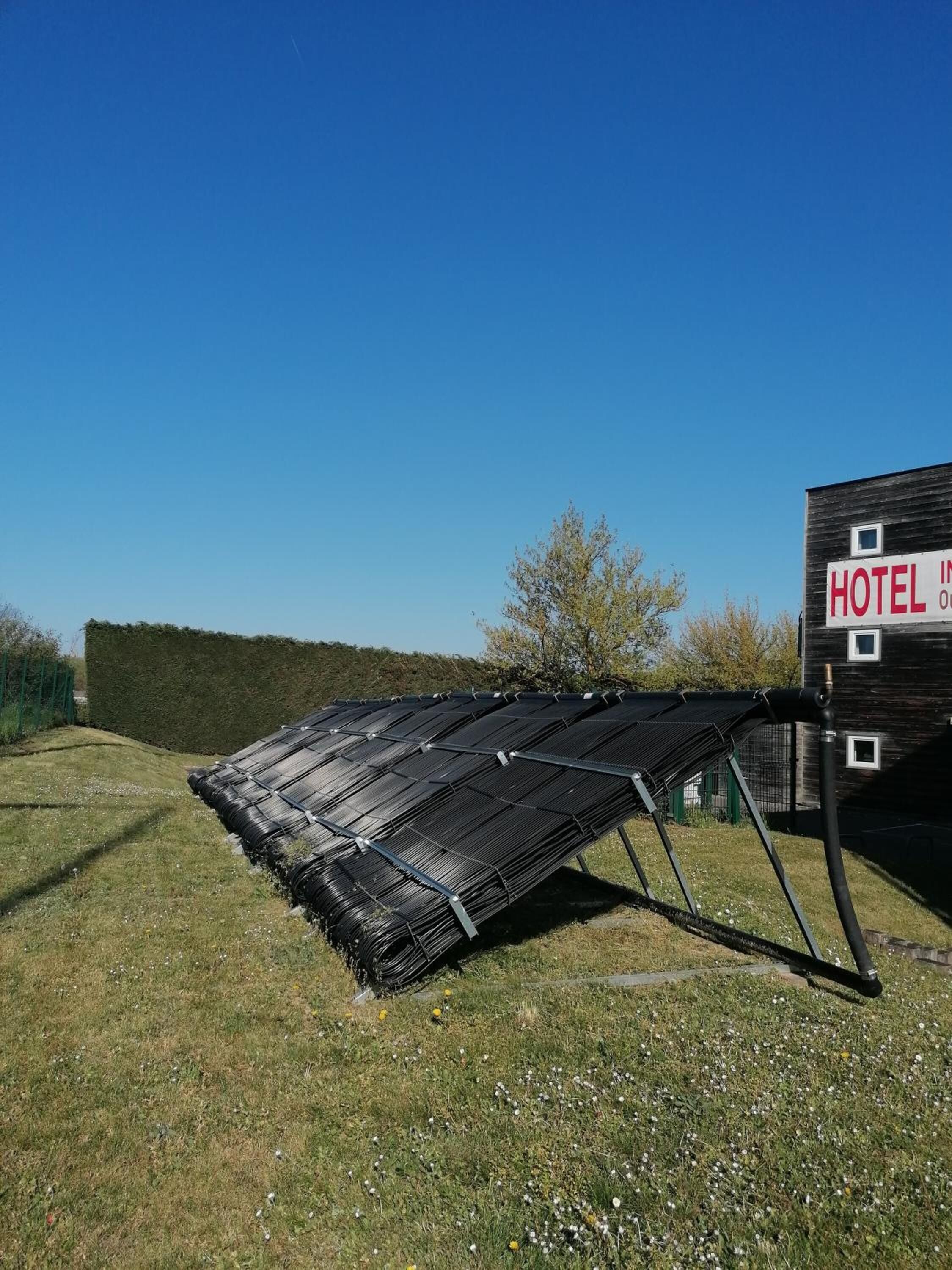 A hotel with a large solar panel installation in the foreground.