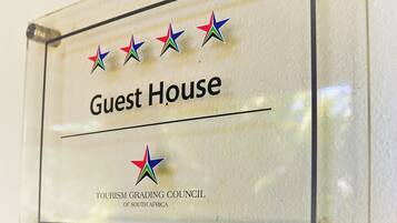 Eine Tafel mit dem Schriftzug 'Guest House' und dem Logo des Tourism Grading Council of South Africa.
