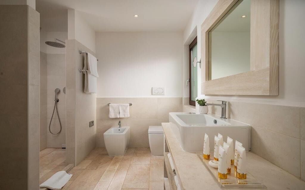 A modern bathroom with a walk-in shower, a bidet, a toilet, and a large bathtub.