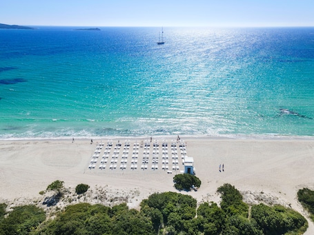 On the beach, white sand, sun loungers, beach umbrellas