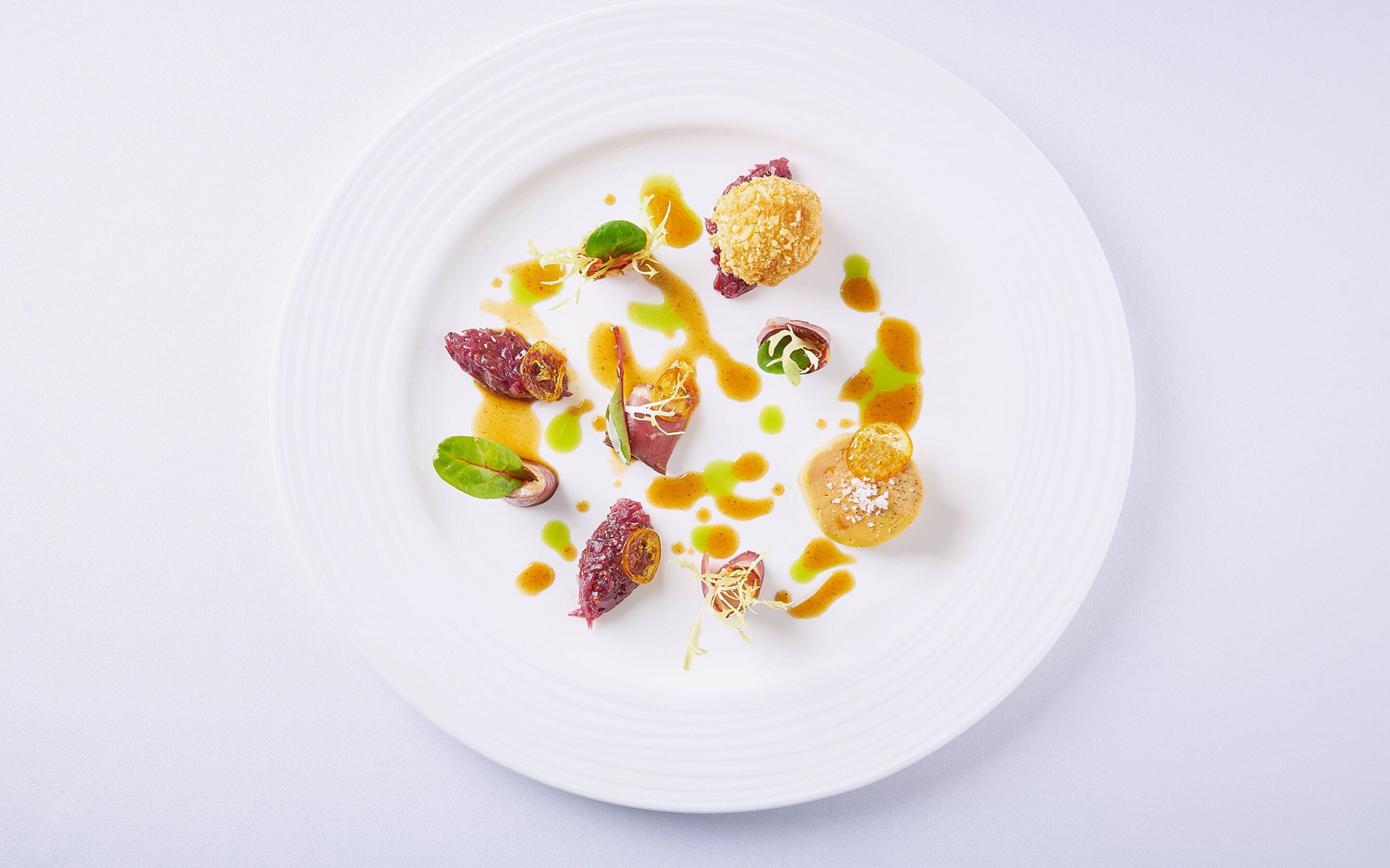A white plate with various food items and sauces.