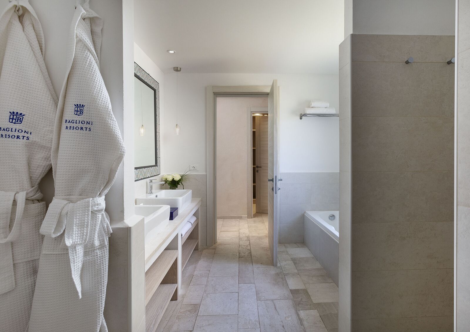 A modern bathroom with two sinks, a mirror, and a shower area.