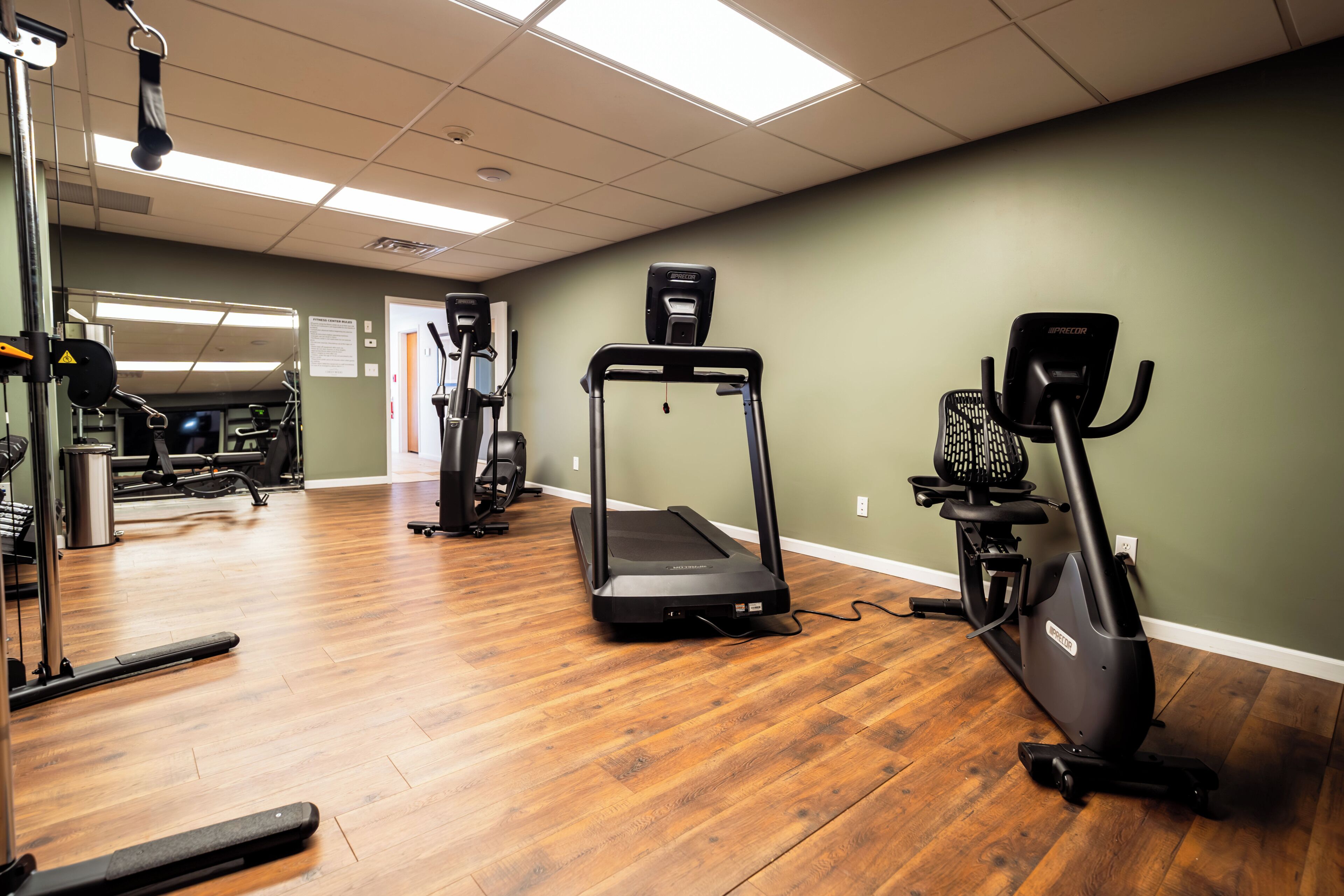 A gym with treadmills, elliptical machines, and weightlifting equipment.