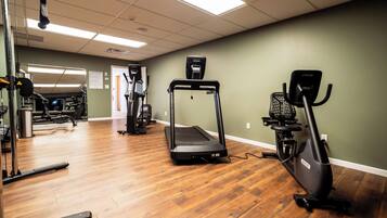 A gym with treadmills, elliptical machines, and weightlifting equipment.