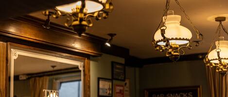 A bar with a sign reading 'THE BLACK LION' and another sign advertising 'BAR SNACKS' for £15.