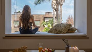 Relax by the window with a clear view of the lush outdoor area, featuring a palm tree-lined landscape.