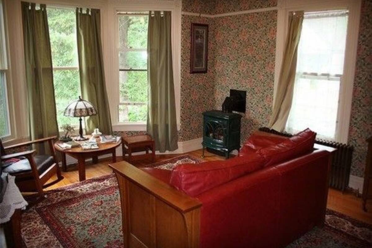 A cozy living room with a red sofa, a wooden coffee table, and a green fireplace.