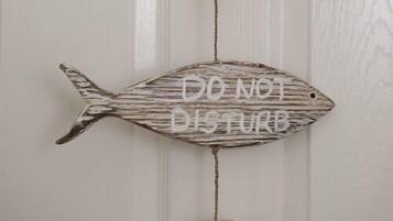 Una decoración con forma de pez que muestra la frase 'DO NOT DISTURB' en una pared.