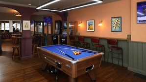 A pool table in a room with wooden flooring, a bar area with stools, and framed artwork on the walls. - The Victoria Hotel (Burnham-on-Sea)
