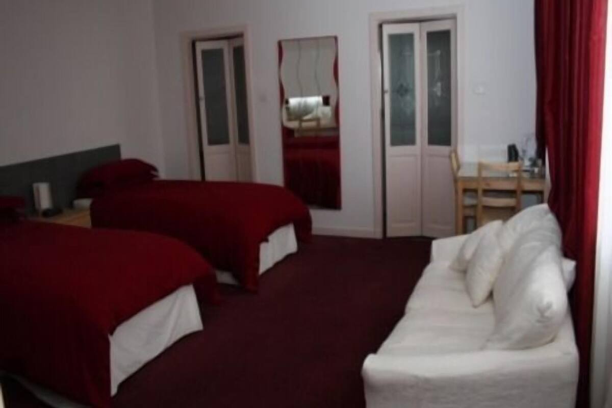 A room with two beds, a desk, and a chair.