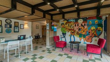 A lobby with a checkered floor, a reception desk, and a mural of musicians.