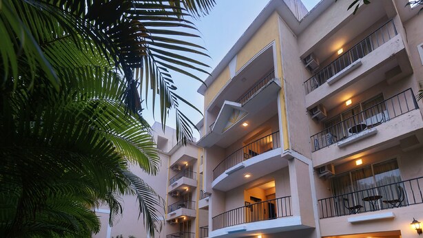Un hotel con piscina, suelo a cuadros y mobiliario exterior.