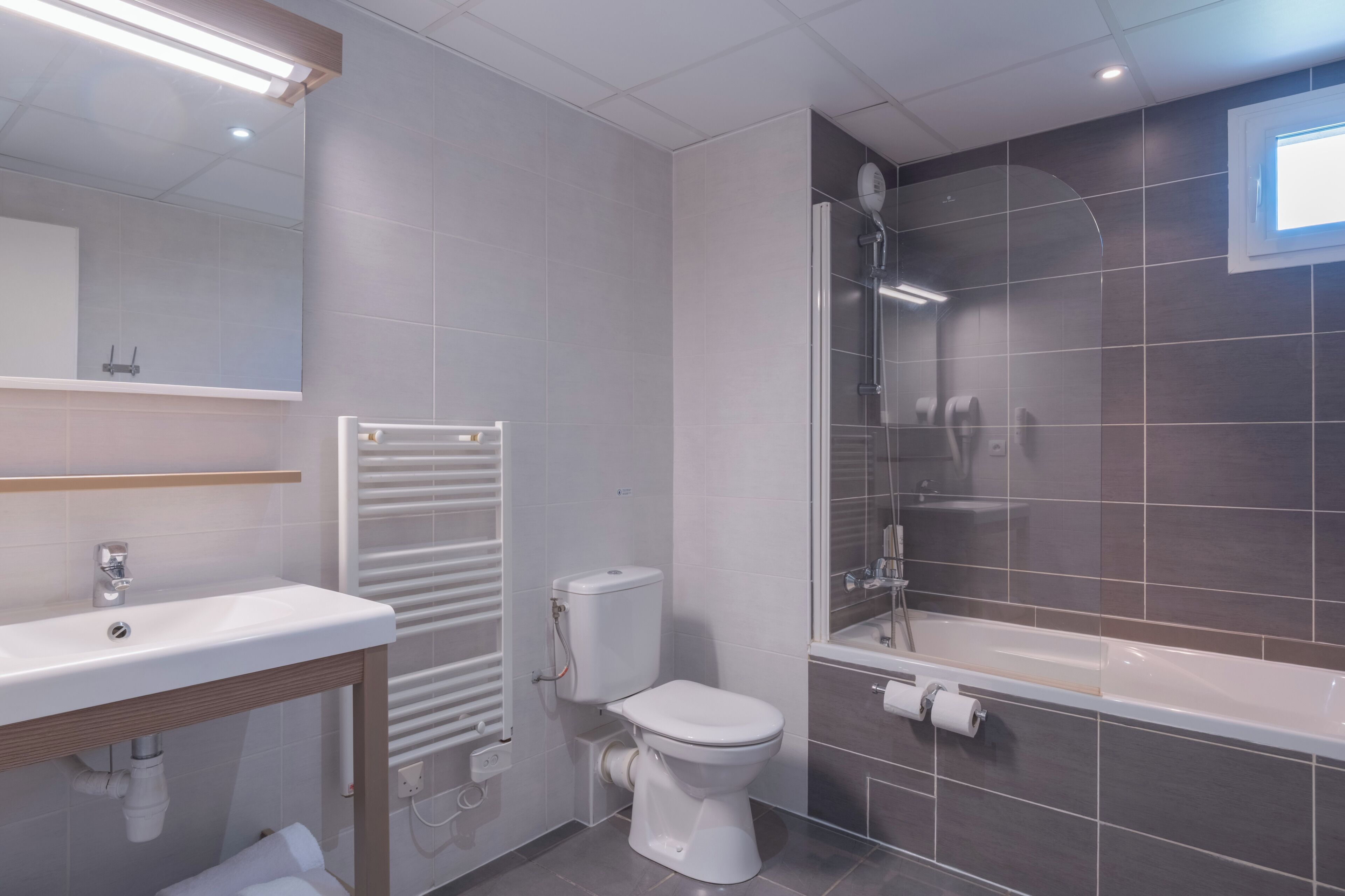 A modern bathroom with a sink, toilet, and shower area.