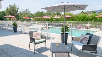 Een seizoensgebonden buitenzwembad en parasols bij het zwembad