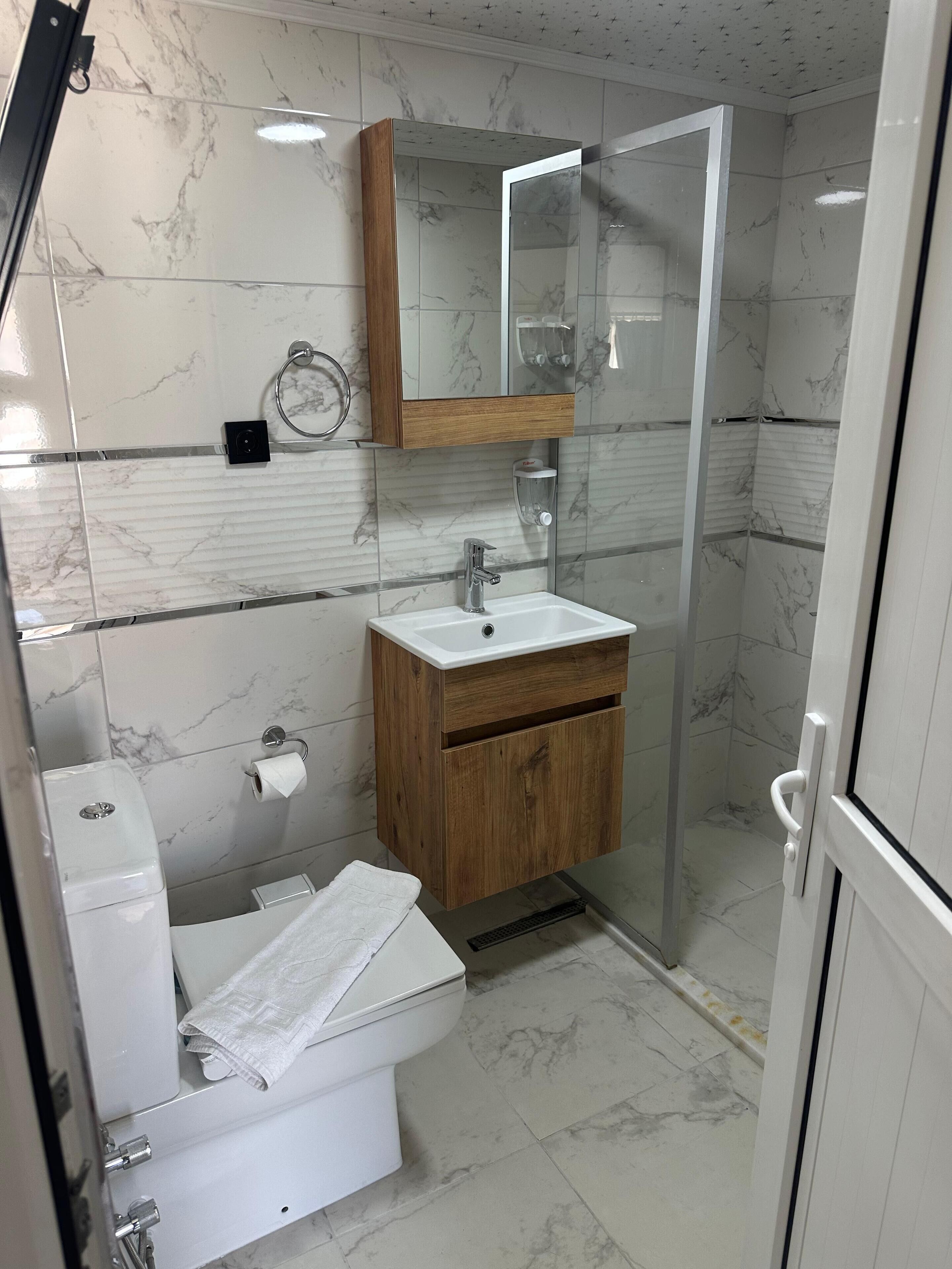 Ein modernes Badezimmer mit Toilette, Waschbecken und Dusche.