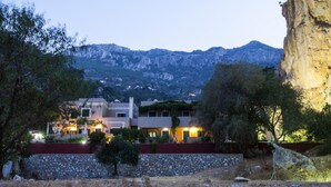 Una vila moderna amb diversos nivells, envoltada per una paret de pedra i vegetació exuberant.