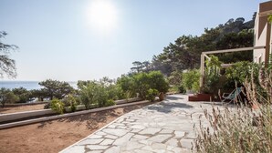 Un camí de pedra que condueix a un edifici amb vista al mar.