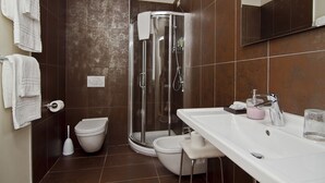 A bathroom with a shower, toilet, and sink.
