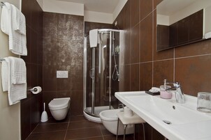 Un bagno con doccia, WC e lavandino.