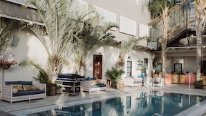 Un espace piscine avec des chaises longues et un bar.