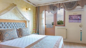 Un dormitorio con una cama grande, vista al mar por una ventana y un cuadro en la pared.