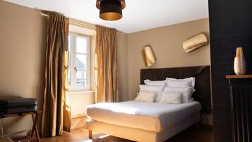 Ein ordentlich eingerichtetes Schlafzimmer mit Bett, Vorhängen, Nachttisch und Lampe.