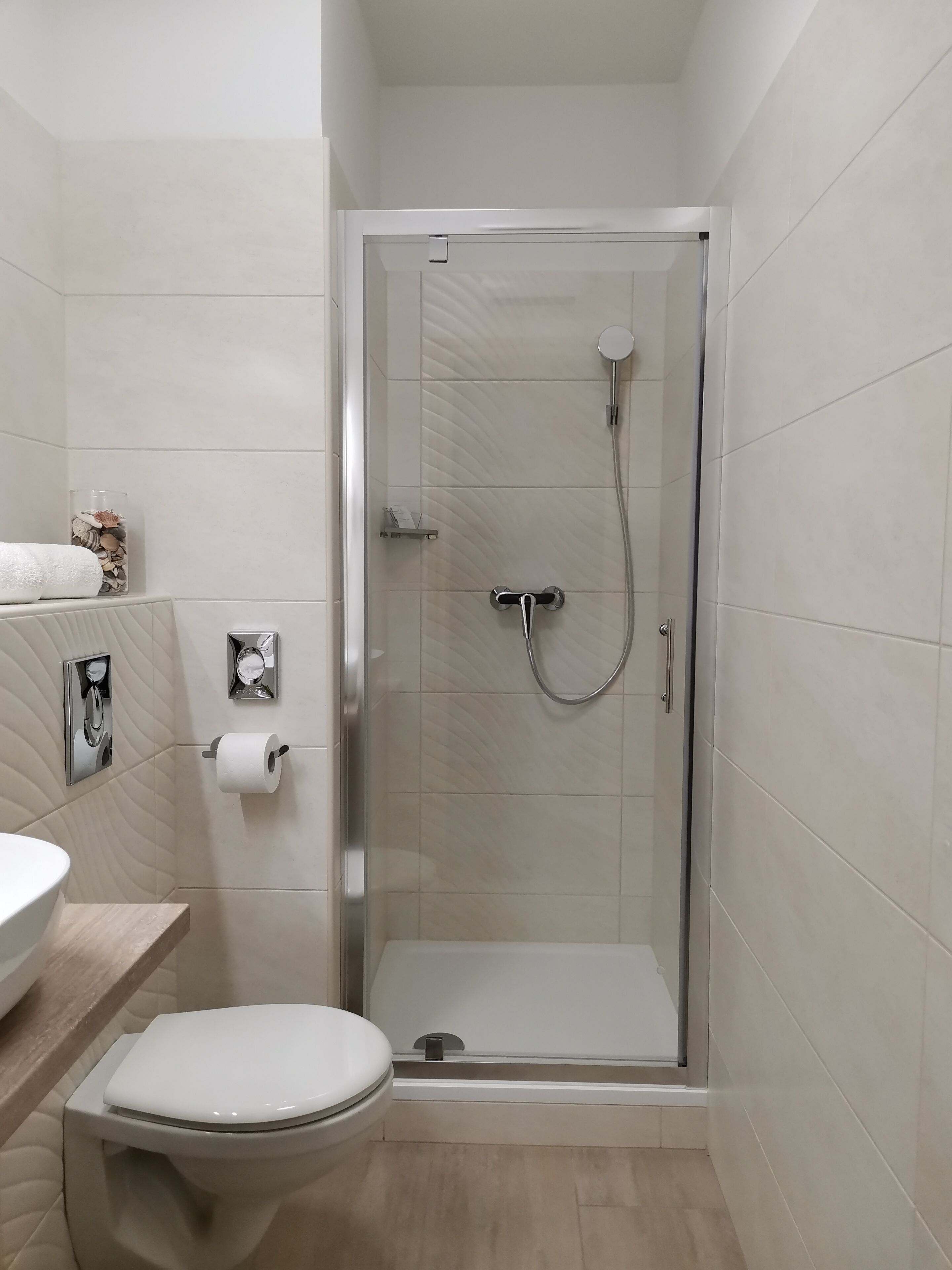 Un baño moderno con ducha de vidrio, inodoro y lavabo.